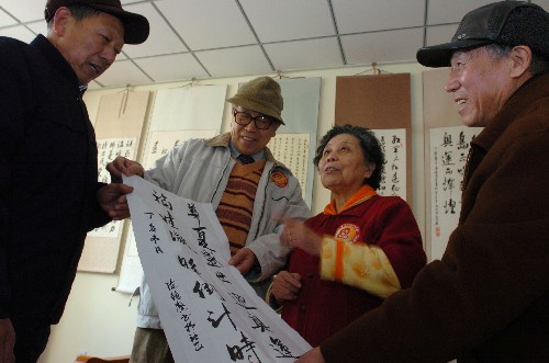 1月9日,青島湛山社區(qū)的居民陳德馨(右二)在展示自己創(chuàng)作的書(shū)法作品。 當(dāng)日,青島湛山社區(qū)居民用書(shū)法、剪紙、絹花制作等民俗藝術(shù)表達(dá)對(duì)北京奧運(yùn)會(huì)的期盼。青島市開(kāi)展“同迎奧帆賽,共建文明城”的主題活動(dòng),在社區(qū)文化建設(shè)中融合人文奧運(yùn)理念,倡導(dǎo)“健康、文明、活力”的社區(qū)文化。 新華社記者 朱崢 攝