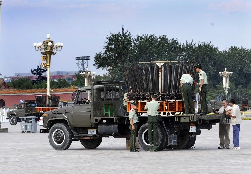 8月2日,武警戰(zhàn)士和工作人員對車載焰火發(fā)射器進行檢查。 8月8日,開幕式進行時,在“鳥巢”頂部、奧林匹克中心區(qū)、天安門、北京市城區(qū)和郊區(qū)等處將燃放3.38萬發(fā)焰火。據(jù)了解,奧運開幕式特效造型焰火燃放由武警北京總隊禮炮支隊擔負,每天施放人員都要對炮筒進行擦拭保養(yǎng),對彈藥裝填、電路連接等環(huán)節(jié)進行反復檢查和訓練,以確保萬無一失。此次特效造型焰火都將在車上完成燃放,以便于移動和運輸。發(fā)射器由多個發(fā)射管組成,每個發(fā)射管都標有刻度,不同的角度是構成不同圖案的關鍵。另外為了體現(xiàn)綠色奧運的理念,通過使用微煙火藥和膛壓發(fā)射技術,大大減輕了焰火燃放時對環(huán)境的污染。 新華社記者李紫恒攝