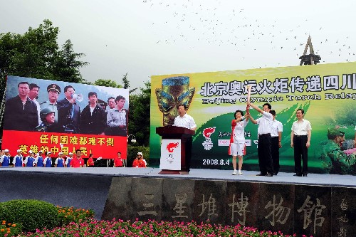 8月4日,中共廣漢市委書記、市人大常委會(huì)主任楊波(前右)與第一棒火炬手江建君(右四)展示火炬。當(dāng)日,北京奧運(yùn)圣火在四川省廣漢市三星堆博物館展示傳遞。 新華社記者劉力航攝