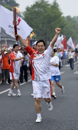 8月6日,火炬手于天華手持火炬?zhèn)鬟f。當(dāng)日,北京奧運(yùn)圣火在北京市傳遞。 新華社記者戚恒攝