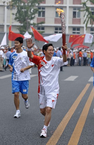 8月6日,火炬手董建岳手持火炬?zhèn)鬟f。當(dāng)日,北京奧運(yùn)圣火在北京市傳遞。 新華社記者戚恒攝