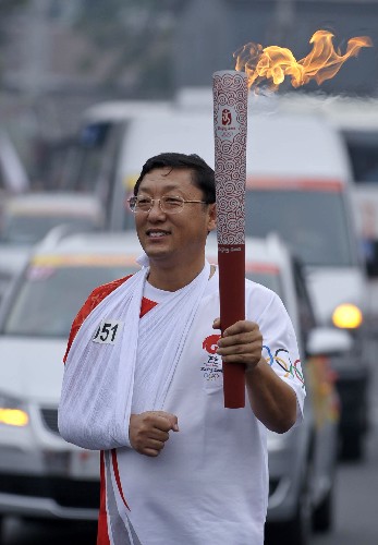 8月6日,火炬手陸海軍手持火炬?zhèn)鬟f。當(dāng)日,北京奧運(yùn)圣火在北京市傳遞。 新華社記者戚恒攝