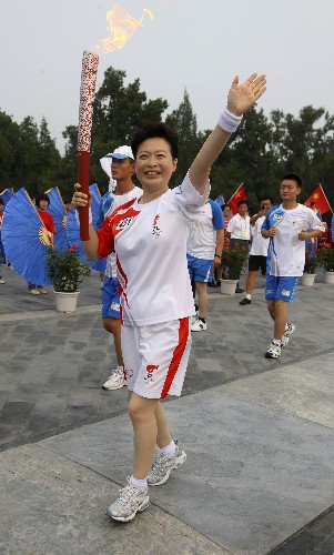 8月6日,火炬手徐滔手持火炬?zhèn)鬟f。當(dāng)日,北京奧運(yùn)圣火在北京市傳遞。 新華社記者邢廣利攝