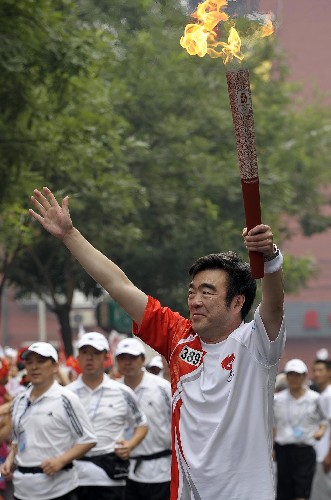 8月6日,火炬手陳小川手持火炬?zhèn)鬟f。當日,北京奧運圣火在北京市傳遞。 新華社記者戚恒攝