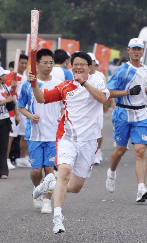 8月7日,火炬手郭耕手持火炬?zhèn)鬟f。當(dāng)日,北京奧運(yùn)圣火在北京市傳遞。 新華社記者戚恒攝