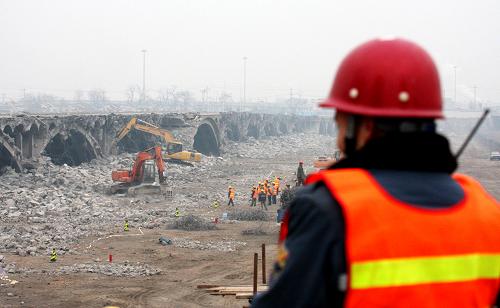 12月28日拍攝的北京盧溝新橋拆除工地。北京盧溝新橋的拆除工作目前已全面展開(kāi),施工單位取消了原來(lái)的爆破方案,采用相對(duì)比較穩(wěn)妥的機(jī)械和人工相結(jié)合的方式拆除。建于1971年的盧溝新橋在今年初局部出現(xiàn)突發(fā)性塌陷,被定為危橋,將拆除后重建。 新華社發(fā)(吳長(zhǎng)青 攝)