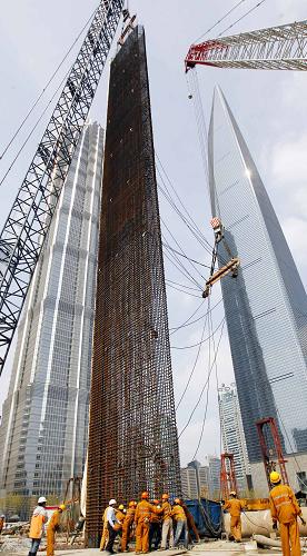 4月11日,工作人員正在將重86噸、高50米、寬6米、厚1.2米的鋼筋籠,放入地下連續(xù)墻的地槽內(nèi)。當(dāng)日,上海中心大廈主樓圍護(hù)地墻開始施工。該大廈地下連續(xù)墻是主樓樁基圍護(hù)工程的一部分,共由65面同等尺寸的鋼筋混凝土墻板組成。上海中心大廈設(shè)計總高度達(dá)632米,是目前國內(nèi)規(guī)劃中的第一高樓。新華社記者 凡軍 攝