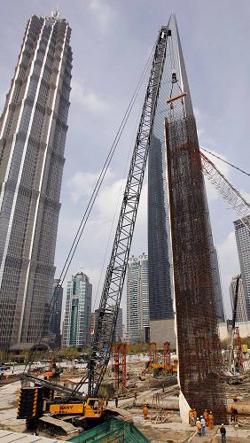 4月11日,工作人員正在將重86噸、高50米、寬6米、厚1.2米的鋼筋籠,放入地下連續(xù)墻的地槽內(nèi)。 當(dāng)日,上海中心大廈主樓圍護(hù)地墻開始施工。該大廈地下連續(xù)墻是主樓樁基圍護(hù)工程的一部分,共由65面同等尺寸的鋼筋混凝土墻板組成。上海中心大廈設(shè)計總高度達(dá)632米,是目前國內(nèi)規(guī)劃中的第一高樓。 新華社記者 凡軍攝