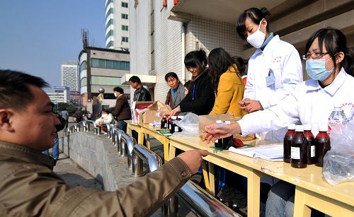 11月13日,一名出租車駕駛員領(lǐng)取藥品。 從當(dāng)日起,湖南中醫(yī)藥大學(xué)第一附屬醫(yī)院等單位聯(lián)合推出“中醫(yī)藥預(yù)防甲流,關(guān)愛你我健康”大型公益活動(dòng),長沙市12000名出租車駕駛員可在指定地點(diǎn)免費(fèi)領(lǐng)取用于預(yù)防甲型H1N1流感的中藥香囊和湯劑。 新華社記者 趙眾志 攝