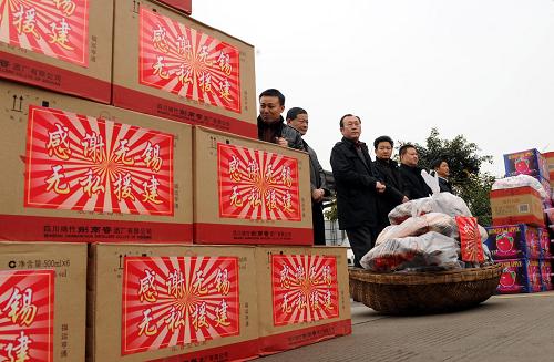 2月14日,當(dāng)?shù)匕傩諡闊o錫援建者送上過春節(jié)的美酒、香腸、臘肉等物品。 當(dāng)日,江蘇無錫援建指揮部和綿竹市漢旺鎮(zhèn)一起為無錫援建者們擺下“壩壩宴”,慶祝農(nóng)歷虎年的第一天。綿竹市領(lǐng)導(dǎo)和當(dāng)?shù)剜l(xiāng)親為他們送上了臘肉、香腸和美酒,村民們還為援建者獻(xiàn)上了感謝的錦旗。 新華社記者 陳燮 攝