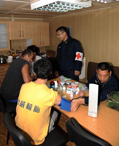 4月13日,在亞丁灣海域,中國海軍第五批護(hù)航編隊(duì)“廣州”艦醫(yī)療人員在“龍發(fā)”號漁船上了解患者病情。 當(dāng)日,正在亞丁灣東部海域執(zhí)行第187批護(hù)航任務(wù)的海軍第五批護(hù)航編隊(duì)“廣州”艦派出醫(yī)療小組前往被護(hù)船只“龍發(fā)”號漁船救治兩名患病船員,并送上蔬菜、水果、飲料等物品。兩名患者被初步診斷為接觸性皮炎,醫(yī)療人員對其進(jìn)行了抗病毒和抗過敏治療,并為其補(bǔ)充營養(yǎng)。 新華社記者劉春暉攝