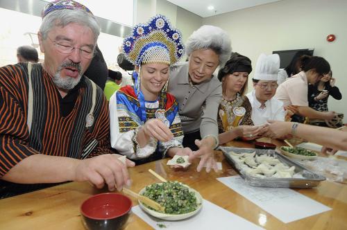 5月4日,聯(lián)合國(guó)合唱團(tuán)成員在上海一家敬老院里學(xué)習(xí)包餛飩。 當(dāng)日,來(lái)上海參加世博會(huì)聯(lián)合國(guó)館開(kāi)館儀式的聯(lián)合國(guó)合唱團(tuán)受邀來(lái)到上海一家敬老院,開(kāi)展“我們一家人”合作交流活動(dòng)。合唱團(tuán)成員用不同語(yǔ)言向老人們問(wèn)候,并現(xiàn)場(chǎng)用中文演唱歌曲,還向老人們學(xué)習(xí)了包餛飩。 新華社發(fā)(張金橋 攝)