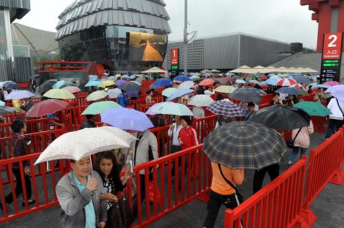 世博雨游 5月5日,游客在中國館前排隊準備入館參觀。 當日,上海迎來世博會正式開幕以來首個降雨天氣,在連續(xù)多個“高溫天”之后,世博園區(qū)內的游客感覺涼爽了不少。據(jù)上海中心氣象臺消息,上海降雨天氣將持續(xù),局部地區(qū)雨量可達中等程度,風力依然較大,未來3至4天的最高氣溫將降至24至25攝氏度。 新華社記者李紫恒攝