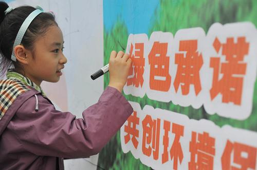 6月5日,在貴陽市人民廣場舉辦的“低碳減排,綠色生活”環(huán)保宣傳系列活動現(xiàn)場,一名小朋友在“綠色承諾,共創(chuàng)環(huán)境保護(hù)模范城市”展板上簽名。 當(dāng)日是第39個(gè)世界環(huán)境日。今年世界環(huán)境日的主題是“多樣的物種,唯一的地球,共同的未來”,我國確定的世界環(huán)境日中國主題為“低碳減排,綠色生活”。 新華社記者 歐東衢 攝