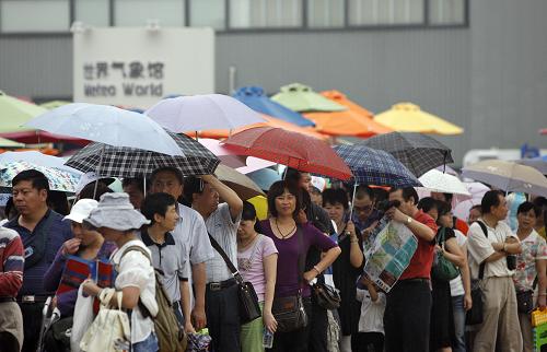 6月14日,游客冒雨在聯(lián)合國館前排隊等候入館。 當(dāng)日是端午節(jié)小長假的第一天,上海世博園的小雨不減游客熱情。截至15時,當(dāng)日入園人數(shù)突破46.19萬。 新華社記者 沈伯韓 攝