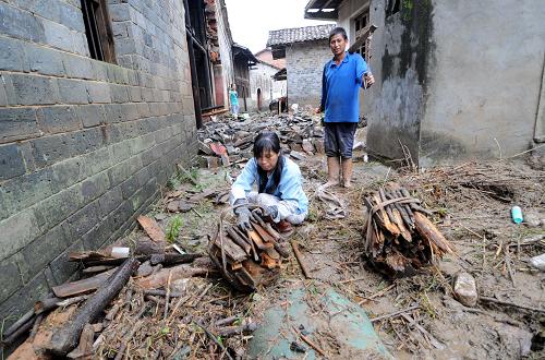 黎川縣德勝鎮(zhèn)新店村村民在清理屋前被洪水沖下來的木頭(6月19日攝)。 近日,受上游水系福建泰寧地區(qū)集中降雨及當(dāng)?shù)卮蟊┯旯餐绊懀魇±璐h遭遇歷史罕見洪水。黎川縣迅速成立了災(zāi)后恢復(fù)和應(yīng)急措施領(lǐng)導(dǎo)小組,指導(dǎo)災(zāi)后自救,及時(shí)設(shè)立災(zāi)民安置點(diǎn)安置受災(zāi)群眾,并組織全縣機(jī)關(guān)黨員干部及相關(guān)技術(shù)人員深入各個(gè)受災(zāi)點(diǎn),對水毀道路橋梁和通信、水電設(shè)施進(jìn)行緊張搶修。目前,該縣2.2萬轉(zhuǎn)移災(zāi)民已經(jīng)全部妥善安置。 新華社記者周科攝