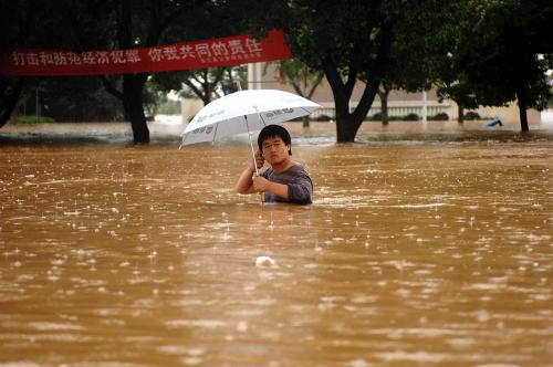 6月20日,在余江縣縣城,一位市民在深及胸口的洪水中撐傘前行。 6月19至20日,江西省余江縣遭遇罕見特大暴雨襲擊,強降雨導(dǎo)致縣城內(nèi)白塔河河水漫過堤岸,余江縣城與外界連通的四條道路全部被洪水淹沒。全縣共有12萬人被困,救援工作正在緊張進行中。 新華社記者 周密 攝