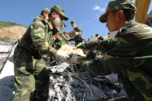 7月5日,成都軍區(qū)駐滇某部官兵在搬運(yùn)從北川縣檔案館廢墟中搶救出的檔案。當(dāng)日,正在對北川縣檔案資料進(jìn)行搶救性挖掘的成都軍區(qū)駐滇某部官兵又成功搶救出兩百余袋珍貴檔案,其中包括百余張描繪北川不同時期地貌的地圖。北川縣檔案館在震前整個庫存是85萬多件,其中國家重點檔案8801件?,F(xiàn)場指揮檔案搶救的趙玄介紹,如果進(jìn)展順利,所有檔案有望于今晚挖掘完畢。 新華社記者 尹棟遜 攝