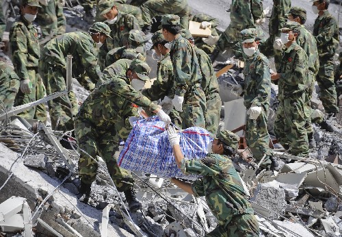 7月5日,成都軍區(qū)駐滇某部官兵在北川縣檔案館廢墟中搶救檔案。當(dāng)日,正在對北川縣檔案資料進(jìn)行搶救性挖掘的成都軍區(qū)駐滇某部官兵又成功搶救出兩百余袋珍貴檔案,其中包括百余張描繪北川不同時期地貌的地圖。北川縣檔案館在震前整個庫存是85萬多件,其中國家重點檔案8801件?,F(xiàn)場指揮檔案搶救的趙玄介紹,如果進(jìn)展順利,所有檔案有望于今晚挖掘完畢。 新華社記者 戴旭明 攝