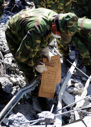 7月5日,成都軍區(qū)駐滇某部戰(zhàn)士在北川縣檔案館廢墟中搶救檔案。當(dāng)日,正在對北川縣檔案資料進(jìn)行搶救性挖掘的成都軍區(qū)駐滇某部官兵又成功搶救出兩百余袋珍貴檔案,其中包括百余張描繪北川不同時期地貌的地圖。北川縣檔案館在震前整個庫存是85萬多件,其中國家重點檔案8801件?,F(xiàn)場指揮檔案搶救的趙玄介紹,如果進(jìn)展順利,所有檔案有望于今晚挖掘完畢。 新華社記者 陳鐸 攝