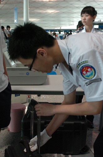 7月20日,安檢人員對(duì)旅客箱包進(jìn)行檢查。新華社記者 陳昌奇 攝