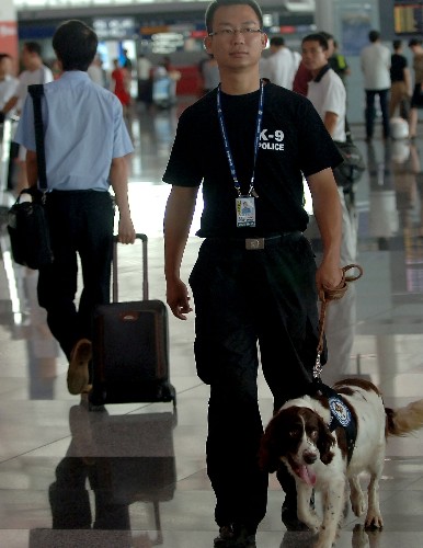 7月20日,一名警察攜警犬在首都機(jī)場(chǎng)3號(hào)航站樓內(nèi)巡邏。新華社記者 公磊 攝