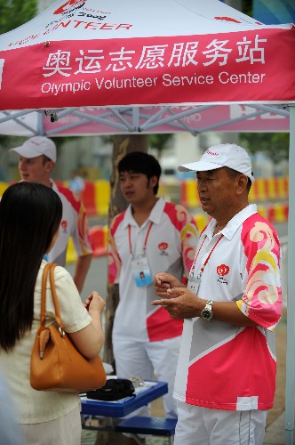 7月28日,青島街頭一奧運(yùn)志愿服務(wù)站里的志愿者為游客解答問題。新華社記者宋振平攝