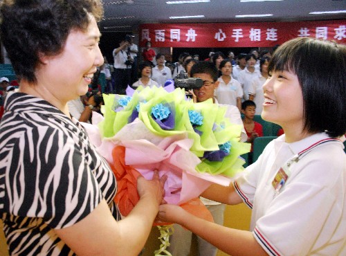 7月28日,川籍學(xué)生江婷將同學(xué)們親手制作的花朵贈給天津中學(xué)王校長。新華社發(fā)(李想 攝)