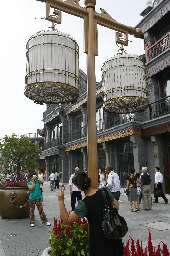 8月20日,游客在前門大街留影。 北京警方近日透露,前門大街出入口已經(jīng)安裝了人員流量電子計數(shù)器,一旦游客數(shù)量達到步行街的最高容量1.8萬人,警方將限制客流進入。 前門大街擁有570年歷史,是北京地表性的老街。在經(jīng)歷一年多時間的保護、修繕后,這條全長840米的步行街于8月7日正式開街。在大街兩旁,12家老字號也重張開業(yè)。警方提醒游客,盡量避開高峰期到前門大街游覽。 新華社記者 魯金博 攝