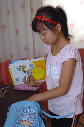 8月31日,略陽(yáng)縣高臺(tái)小學(xué)學(xué)生袁文靜在整理書包,為次日開學(xué)做準(zhǔn)備。陜西省地震重災(zāi)區(qū)略陽(yáng)縣23000多名中小學(xué)生將于9月1日開學(xué)。 新華社記者丁海濤攝