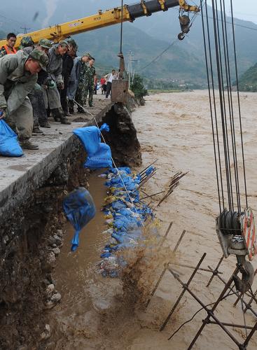 9月24日,成都軍區(qū)駐滇某防化團(tuán)戰(zhàn)士正在緊急搶修綿陽通往北川的公路。新華社記者 陳燮 攝