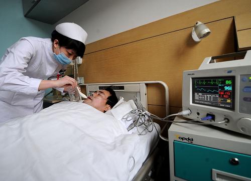 2月23日,在山西省人民醫(yī)院,一名護(hù)士正在護(hù)理受傷的礦工張慶高。張慶高目前已暫時(shí)脫離生命危險(xiǎn)。新華社記者 燕雁 攝