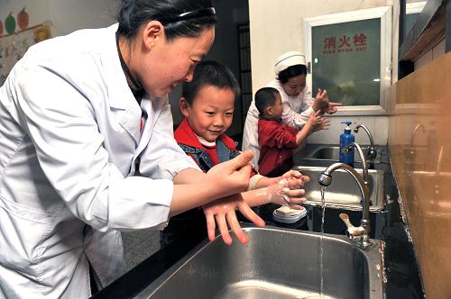 4月8日,鶴壁市星海幼兒園的小朋友在醫(yī)務(wù)人員的指導(dǎo)下洗手消毒。針對目前我國一些地區(qū)出現(xiàn)的手足口病疫情,河南省鶴壁市各幼兒園采取相關(guān)預(yù)防措施,嚴(yán)密防控手足口病,保證孩子們的身體健康。新華社發(fā)(李國慶 攝)