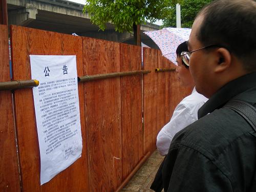5月26日,株洲市民在觀看株洲市建設(shè)局、公安局關(guān)于紅旗路高架橋爆破拆除的公告。新華社記者 蘇曉洲 攝