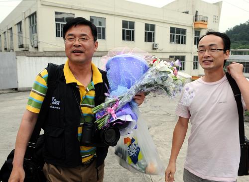 5月27日,福州一名甲型H1N1流感密切接觸者(左)解除醫(yī)學觀察后走出隔離區(qū)。當日,與福建省首例輸入性甲型H1N1流感患兒經香港同機返閩的30名密切接觸者,經過1周時間的醫(yī)學觀察沒有發(fā)現異常,解除醫(yī)學觀察回家。新華社記者 張國俊 攝