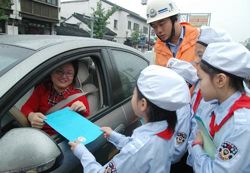 9月22日,蘇州市“小交警”向車主發(fā)放“綠色出行”倡議書。當(dāng)天是“無車日”,全國各地群眾積極行動,倡導(dǎo)步行、騎自行車、乘公交車等方式綠色出行。新華社發(fā)(朱桂根 攝)