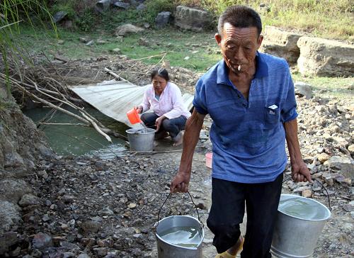 9月23日,邵陽(yáng)縣南山村村民在掘井隊(duì)掘出的一口井里取水。新華社發(fā)(李?lèi)?ài)民 攝)