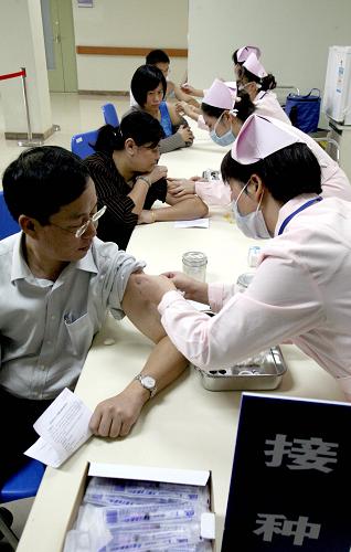 10月15日,上海公共衛(wèi)生臨床中心的醫(yī)護(hù)人員在接種甲型H1N1流感疫苗。新華社發(fā)
