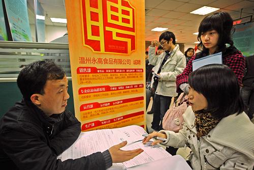 11月28日,一名應(yīng)聘者(前右)在向一家溫州農(nóng)業(yè)企業(yè)的招聘人員了解上崗要求。新華社記者 譚進(jìn) 攝