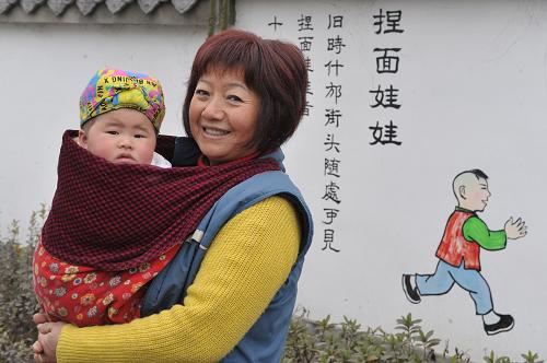 1月26日,什邡市東岳村的吳朝玉抱著自己的外孫女在村中散步。新華社記者 魯鵬 攝