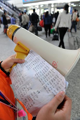 負(fù)責(zé)回答旅客問詢的志愿者身上都帶有一張自己抄寫的紙條,上面有火車時刻表和候車、乘車地點(1月28日攝)。新華社記者 盧漢欣 攝