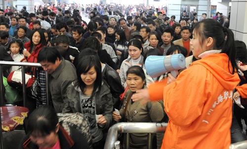 1月28日,一名志愿者在引導(dǎo)旅客上車。新華社記者 盧漢欣 攝