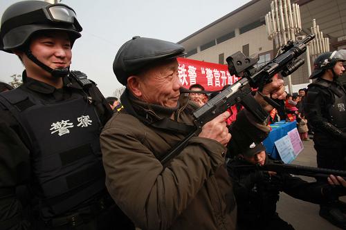 1月28日,旅客在武漢鐵路民警指導(dǎo)下體驗(yàn)警用裝備。 新華社發(fā)(趙軍 攝)