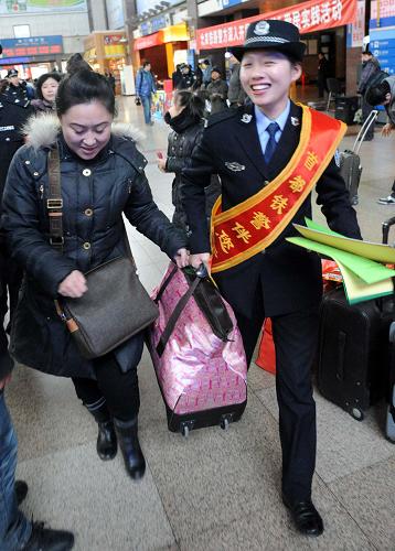 1月28日,一位女鐵警在北京站幫助旅客提行李。新華社記者 唐召明 攝