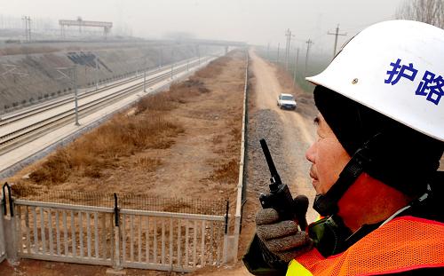 一位護(hù)路工在洛陽(yáng)附近的高速鐵路旁執(zhí)勤(1月13日攝)。新華社記者 王頌 攝