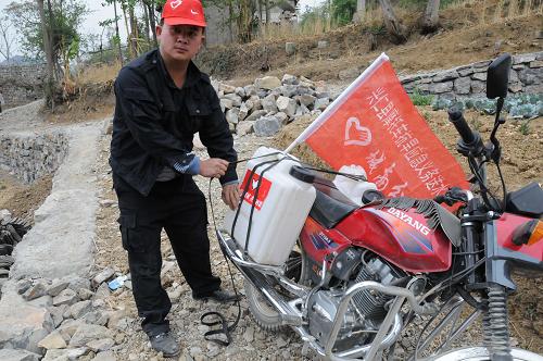 貴州興仁縣年僅19歲的青年志愿者、共青團(tuán)員楊貞權(quán)為村里困難戶義務(wù)送水(3月24日攝)。新華社記者 石新榮 攝