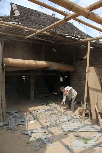 4月21日,勐臘縣勐侖鎮(zhèn)曼賀科村的村民在受損房屋內(nèi)打掃。新華社發(fā)(李云生 攝)