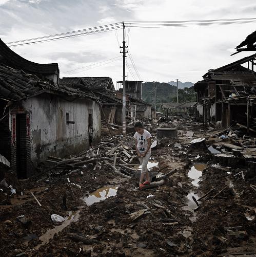 6月28日,在福建省建陽(yáng)市芹口村,一位小女孩走在村中泥濘的路上。新華社記者 沈伯韓 攝