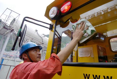 7月3日,在蘭渝鐵路西秦嶺隧道2標的施工現場,施工人員在擦洗軌道車的玻璃。新華社記者 高健鈞 攝