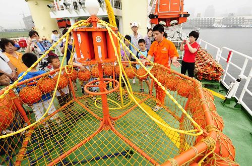 7月10日,專(zhuān)業(yè)救助船“北海救113”輪的工作人員在向觀眾介紹船上的救援設(shè)備。新華社發(fā) (郭昱 攝)